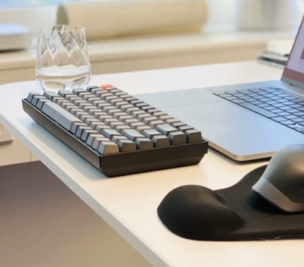 Picture of a Keyboard and Glass on a Desk